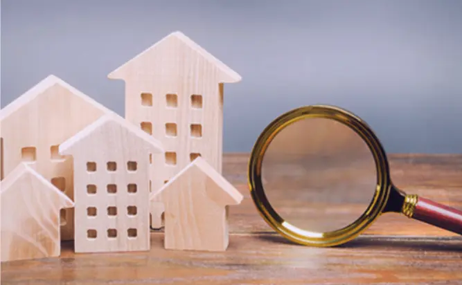 Property models and magnifying glass representing valuation analysis